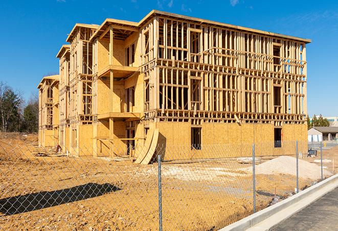 a temporary chain link fence in front of a building under construction, ensuring public safety in Visalia